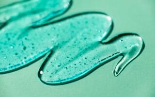 Sabonete facial espalhado em superfície verde-menta.