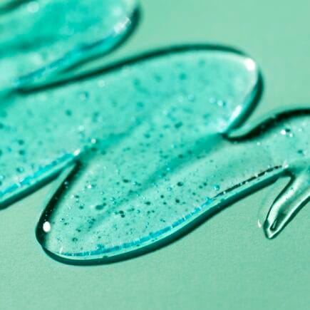 Sabonete facial espalhado em superfície verde-menta.