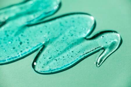 Sabonete facial espalhado em superfície verde-menta.