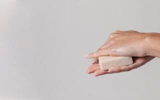 mãos segurando sabonete facial