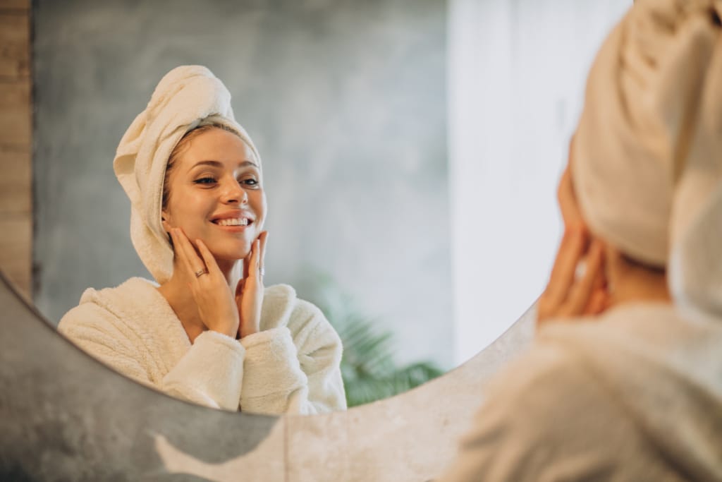 woman-looking-at-herself-in-the-mirror-examining-her-skin-type-how to identify your skin type